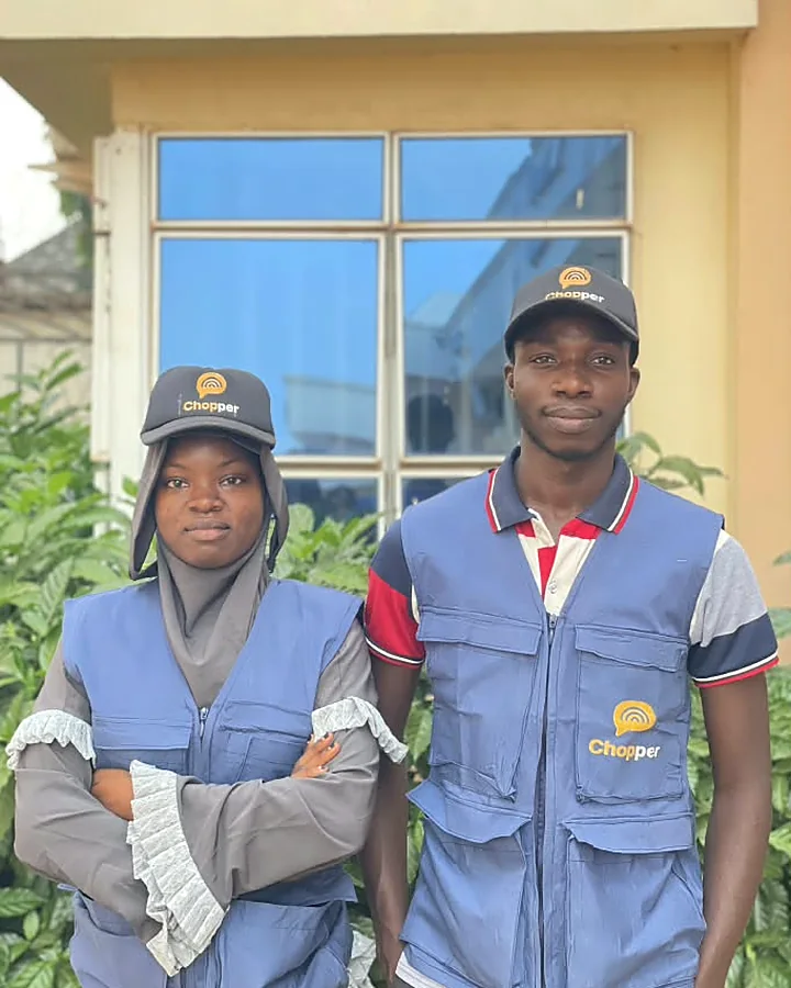 Two ChopChat support team members in Chopper caps and blue vests, standing side by side.